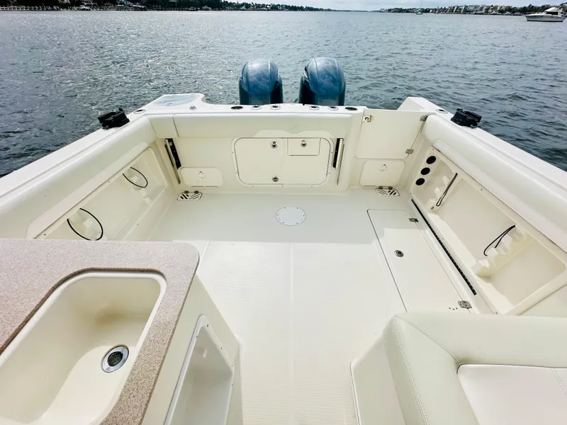 Slide: The Image of 2014 Sailfish 275 DC boat deck with dual engines on a calm lake. - 11