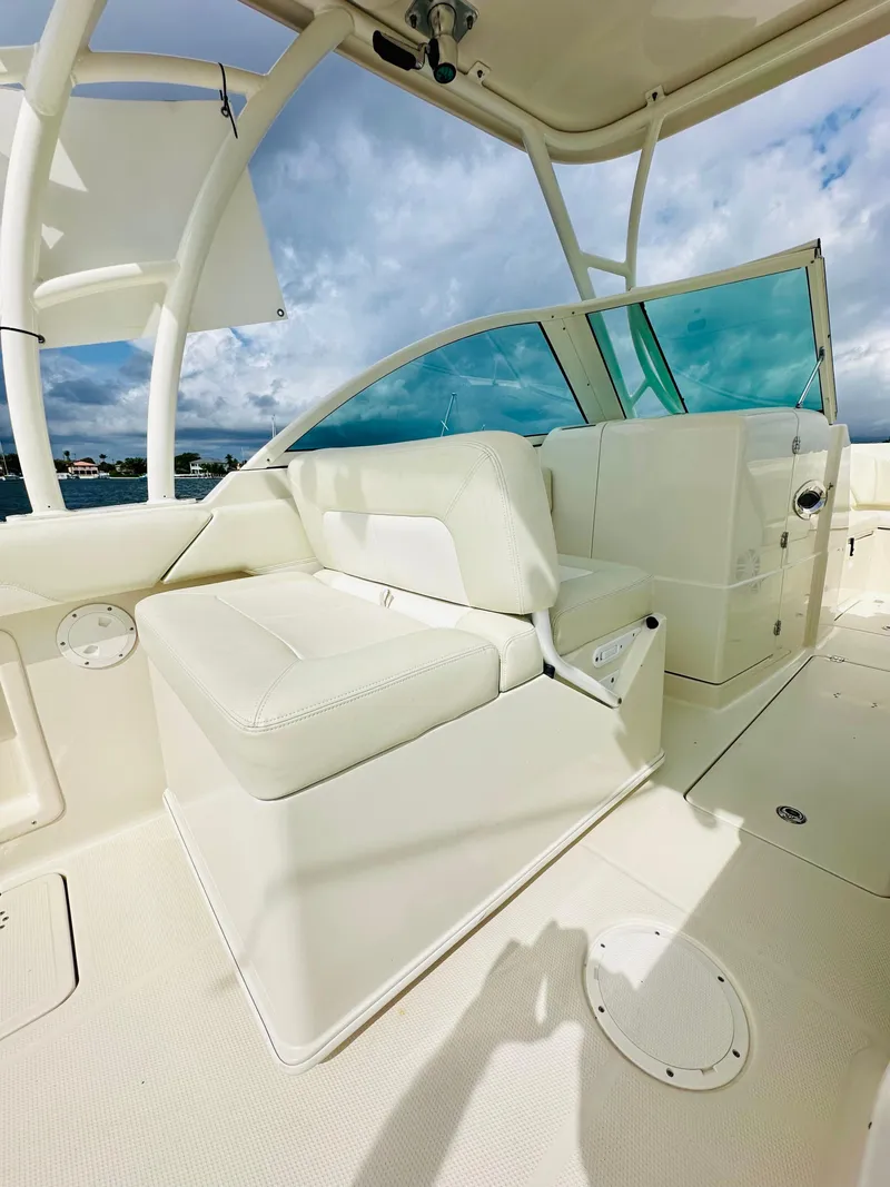 Slide: The Image of 2014 Sailfish 275 DC boat interior with white seating and clear skies. - 13