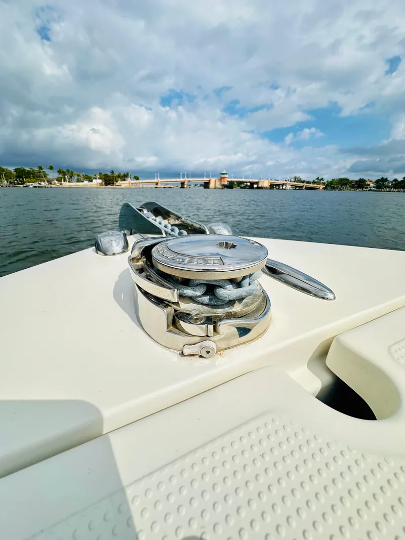 Slide: The Image of 2014 Sailfish 275 DC boat on water, featuring anchor winch, under cloudy sky. - 14