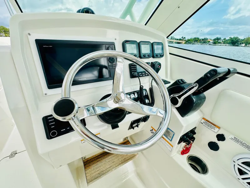 Slide: The Image of 2014 Sailfish 275 DC boat dashboard with steering wheel and navigation controls. - 6