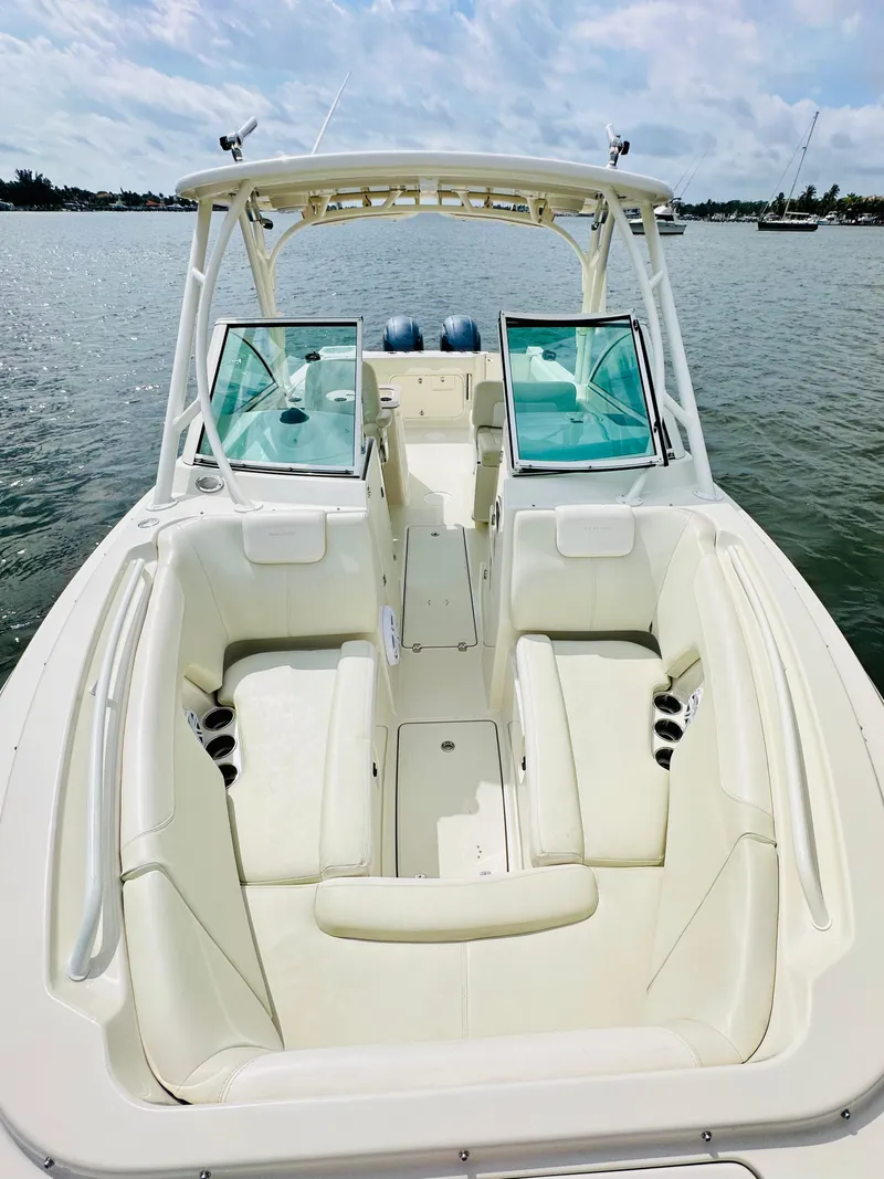 Slide: The Image of 2014 Sailfish 275 DC boat with open deck and seating on a calm water backdrop. - 7