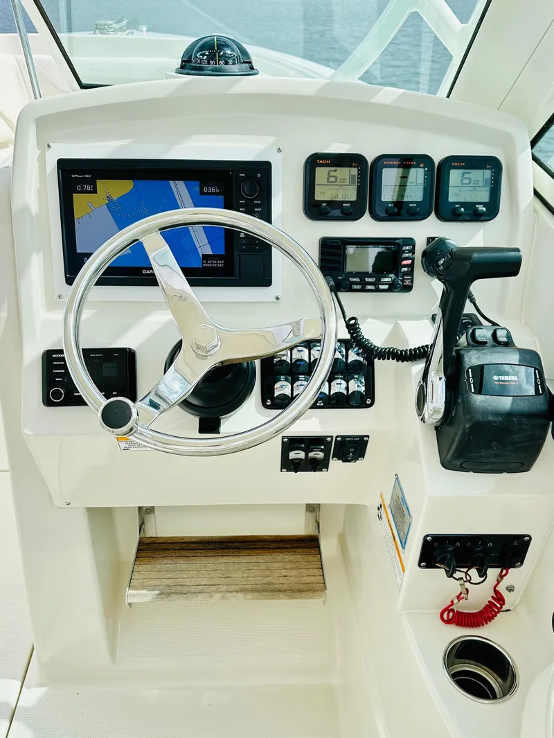 Slide: The Image of 2014 Sailfish 275 DC boat dashboard with navigation and control instruments. - 9
