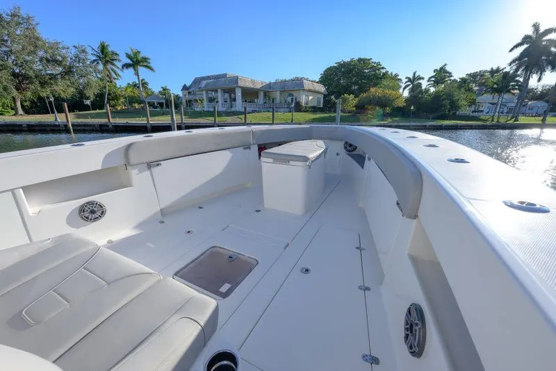 Slide: The Image of 2022 SeaVee 390Z boat interior with seating, docked near waterfront homes. - 20