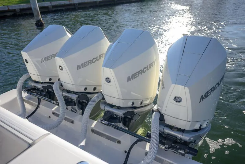 Slide: The Image of Triple Mercury outboard engines on a 2022 SeaVee 390Z boat, docked by the water. - 32