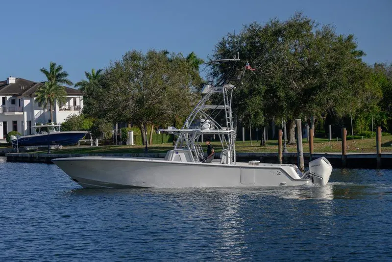 Slide: The Image of 2022 SeaVee 390Z boat cruising on a calm waterway near a residential area. - 4