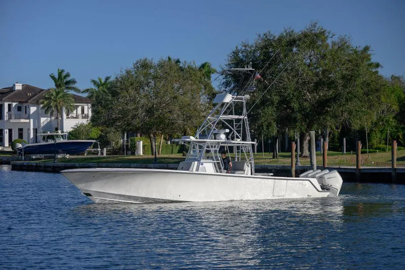 Slide: The Image of 2022 SeaVee 390Z boat on calm water near a residential area with trees. - 5