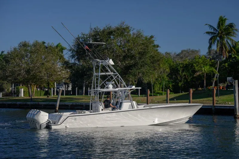 Slide: The Image of 2022 SeaVee 390Z boat cruising on a calm waterway with lush greenery in the background. - 6