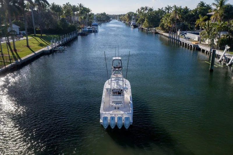 Slide: The Image of 2022 SeaVee 390Z boat cruising through a scenic canal lined with palm trees. - 7