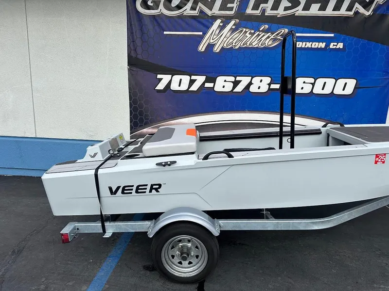 Slide: The Image of 2023 Veer V13 boat on trailer, displayed outside a marine shop. - 6