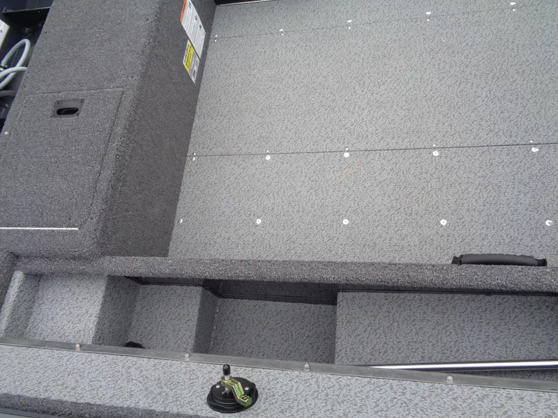 Slide: The Image of 2025 Lund 1650 Rebel XL Tiller boat interior with gray textured flooring. - 13