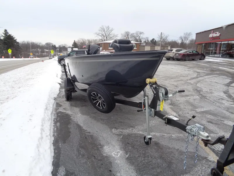 Slide: The Image of 2025 Lund 1650 Rebel XL Tiller boat on trailer in snowy parking lot. - 17