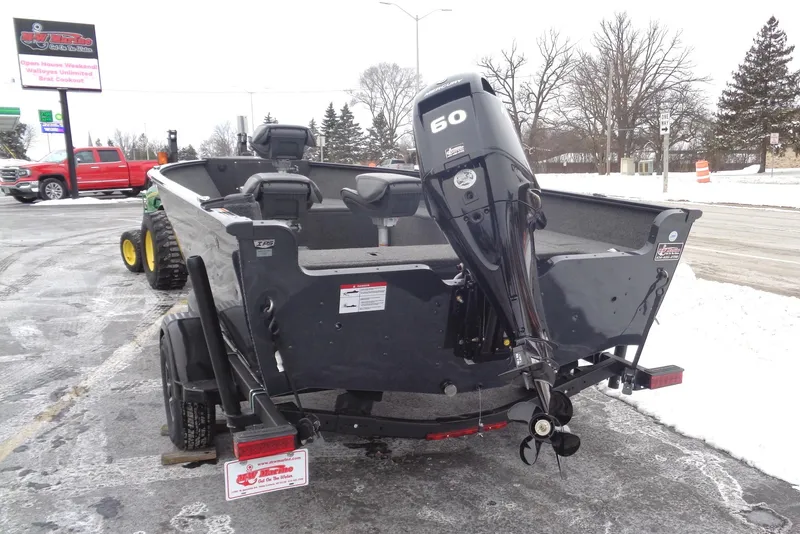 Slide: The Image of 2025 Lund 1650 Rebel XL Tiller boat with 60 HP motor in snowy parking lot. - 18