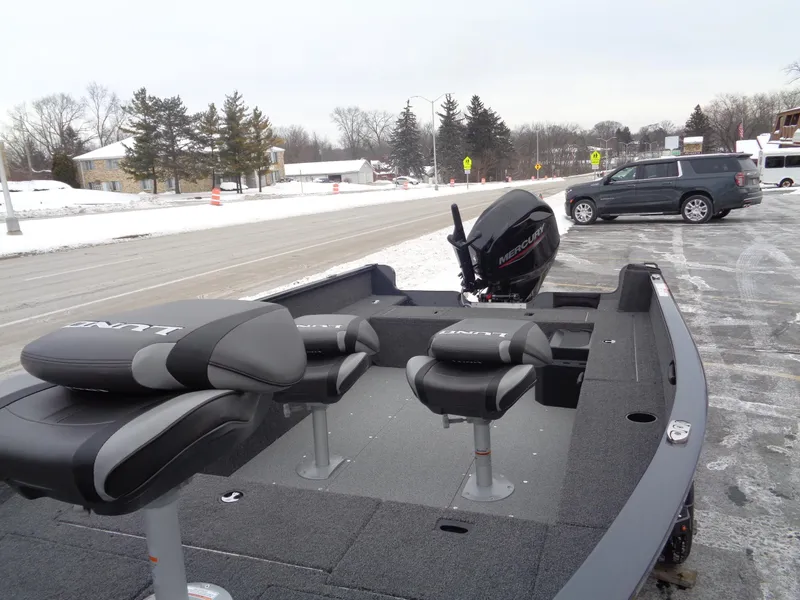 Slide: The Image of 2025 Lund 1650 Rebel XL Tiller boat with seats, parked on snowy roadside. - 6