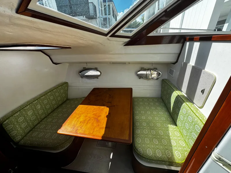 Slide: The Image of Interior of 1991 Tiara Yachts 3600 Convertible with green seating and wooden table. - 24
