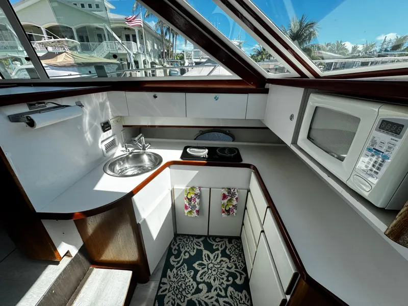Slide: The Image of 1991 Tiara Yachts 3600 Convertible kitchen with sink, stove, and microwave. - 27