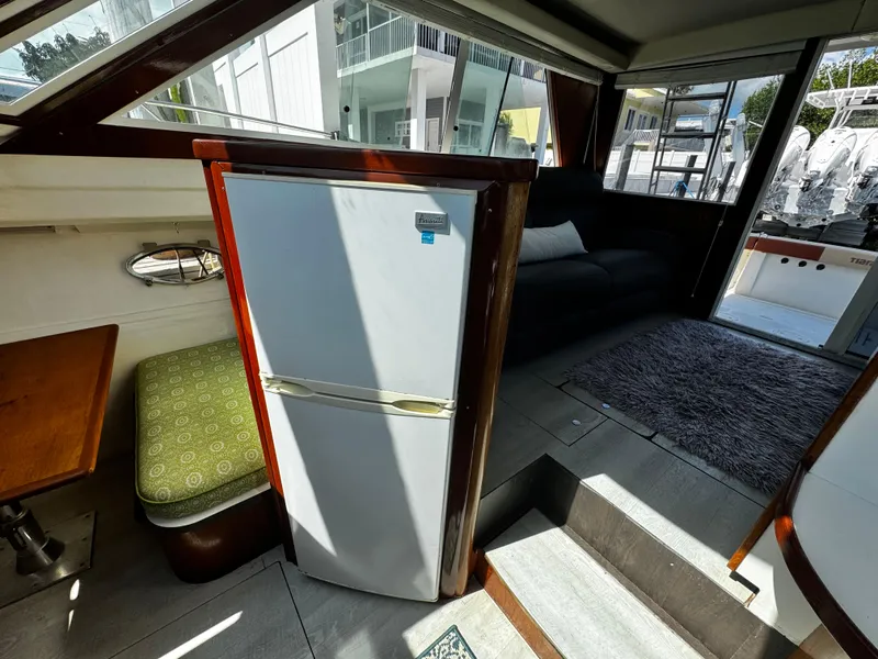 Slide: The Image of Interior of 1991 Tiara Yachts 3600 Convertible with fridge and seating area. - 29