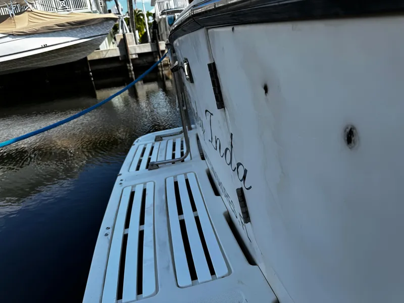 Slide: The Image of 1991 Tiara Yachts 3600 Convertible docked, showing rear deck and water reflection. - 5