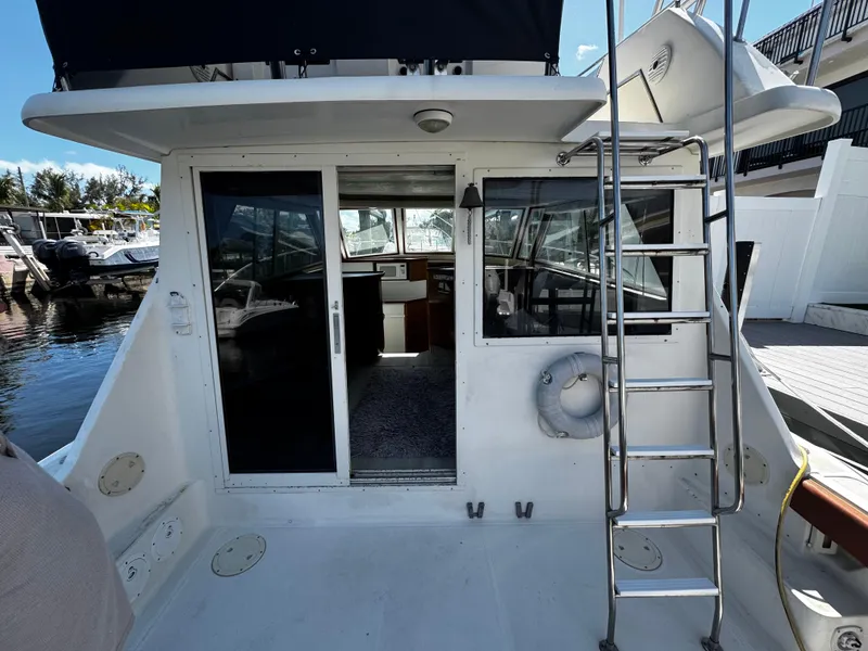 Slide: The Image of 1991 Tiara Yachts 3600 Convertible, rear view with sliding doors and ladder, docked at marina. - 6