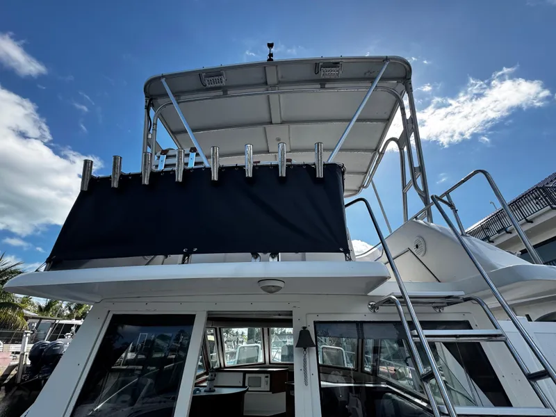Slide: The Image of 1991 Tiara Yachts 3600 Convertible, rear view with flybridge and ladder under blue sky. - 7