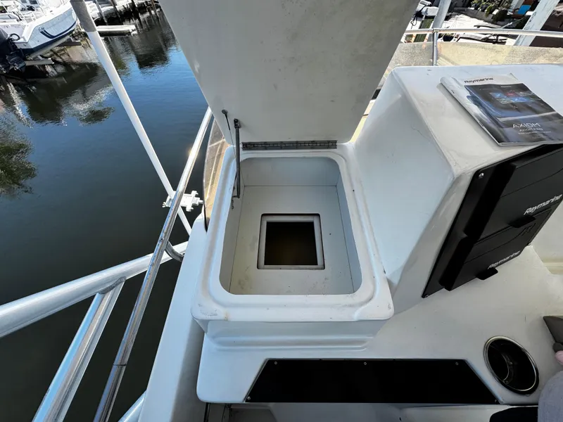 Slide: The Image of 1991 Tiara Yachts 3600 Convertible deck with open storage compartment by the water. - 9
