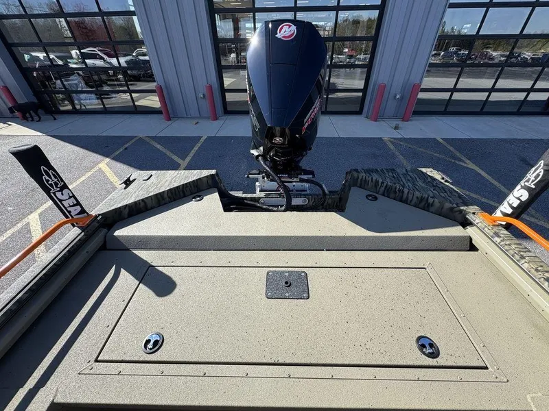 Slide: The Image of 2025 SeaArk ProCat 240 boat with powerful outboard motor, parked outside a building. - 10