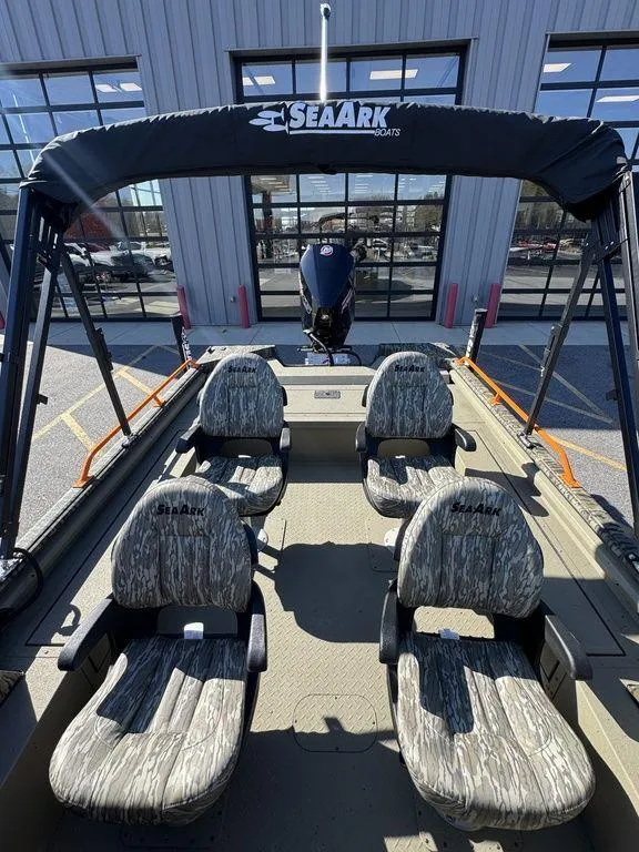 Slide: The Image of 2025 SeaArk ProCat 240 boat with camo seats and canopy, parked outside a building. - 11