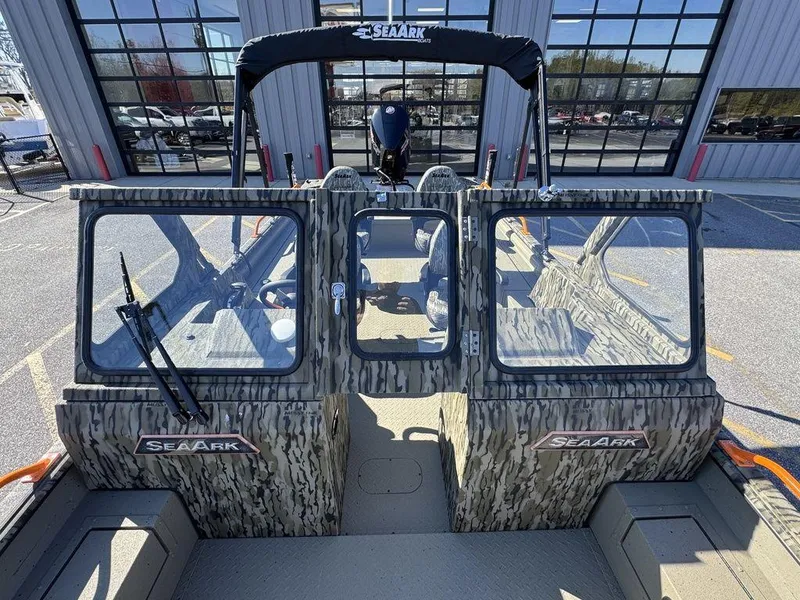 Slide: The Image of 2025 SeaArk ProCat 240 boat with camouflage design, docked near a modern building. - 9