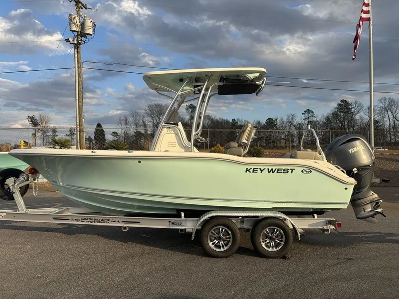 The Image of 2025 Key West 219fs boat on trailer, parked outdoors under cloudy sky. - 0