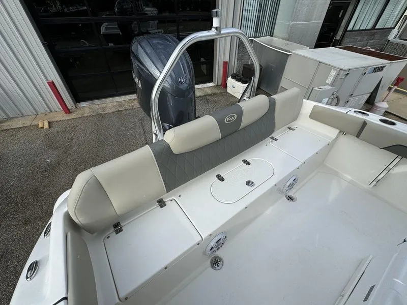 Slide: The Image of 2025 Key West 219fs boat interior with seating and motor, parked outdoors. - 14