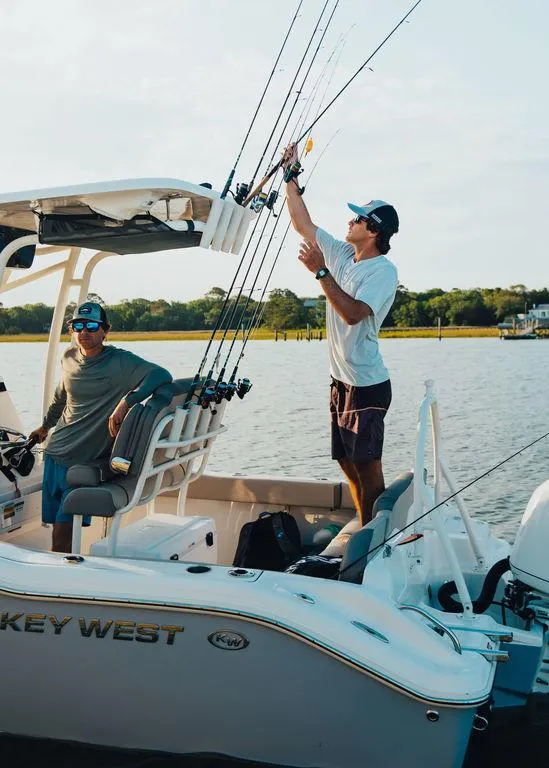 Slide: The Image of Two people fishing on a 2025 Key West 219fs boat in a scenic waterway. - 16