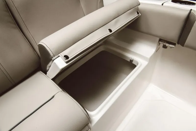 Slide: The Image of 2025 Key West 219fs boat seat with open storage compartment, showcasing beige upholstery. - 17