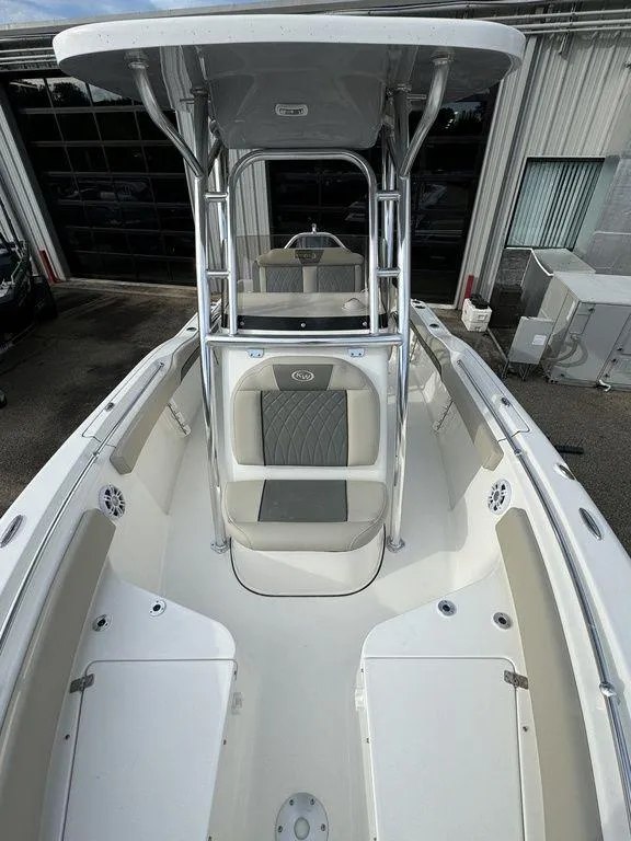 Slide: The Image of 2025 Key West 219fs boat interior with seating and T-top, docked at a marina. - 7