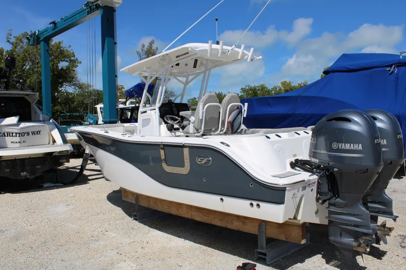 Slide: The Image of 2021 Sea Fox 268 Commander boat with dual Yamaha engines, docked outdoors. - 5