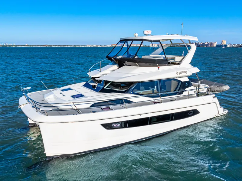 Slide: The Image of 2022 Aquila 44 Yacht cruising on open water under clear blue skies. - 0