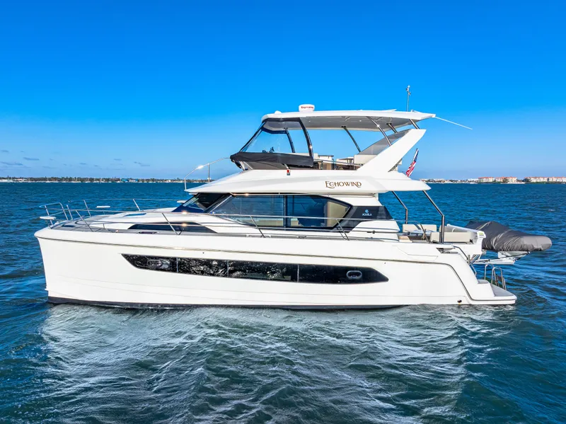 Slide: The Image of 2022 Aquila 44 Yacht cruising on open water under clear blue skies. - 1