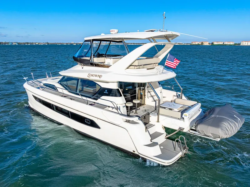 Slide: The Image of 2022 Aquila 44 Yacht cruising on open water, featuring sleek design and American flag. - 13