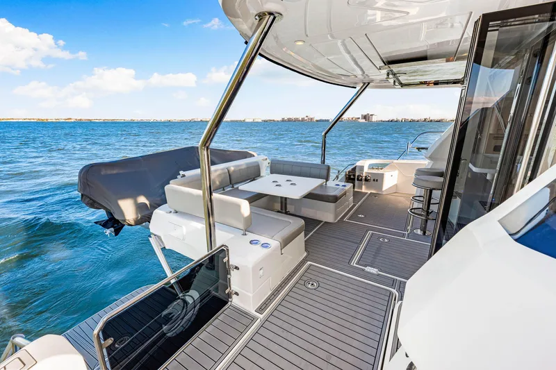 Slide: The Image of Aquila 44 Yacht 2022, spacious deck with seating, overlooking serene ocean waters. - 16