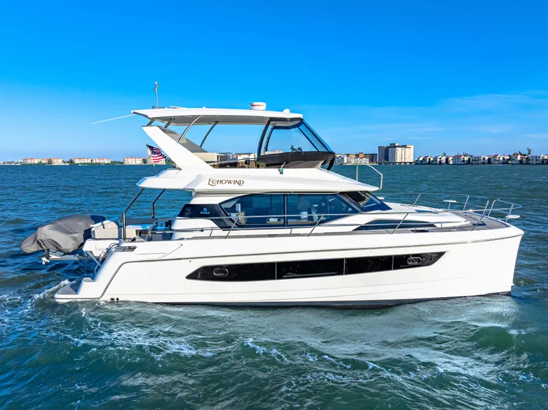 Slide: The Image of 2022 Aquila 44 Yacht cruising on open water under clear blue skies. - 8