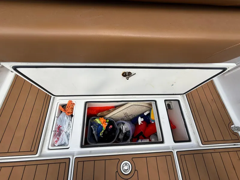 Slide: The Image of Storage compartment on a 2010 Fountain 38 LX boat with various items inside. - 15