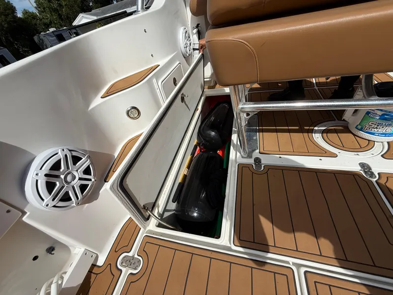 Slide: The Image of 2010 Fountain 38 LX boat interior with storage compartment and brown seating. - 16