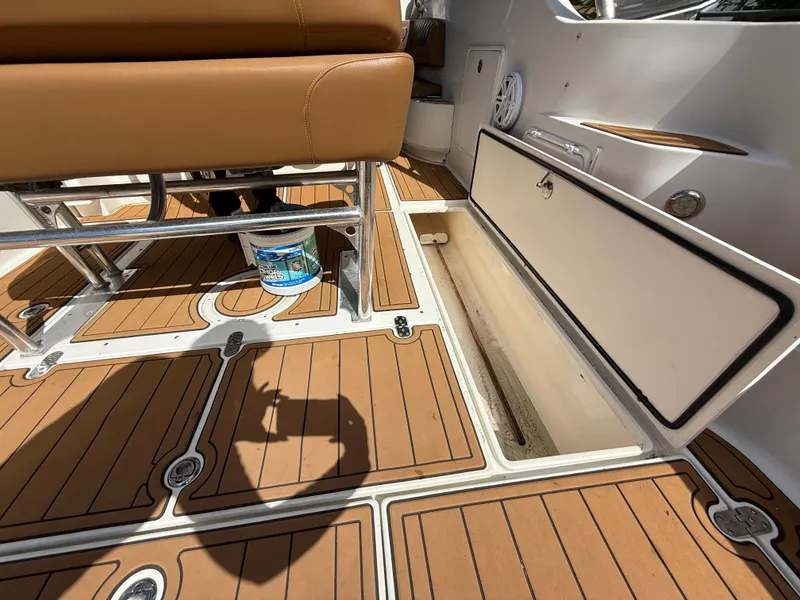 Slide: The Image of 2010 Fountain 38 LX boat interior with open storage compartment and teak flooring. - 17