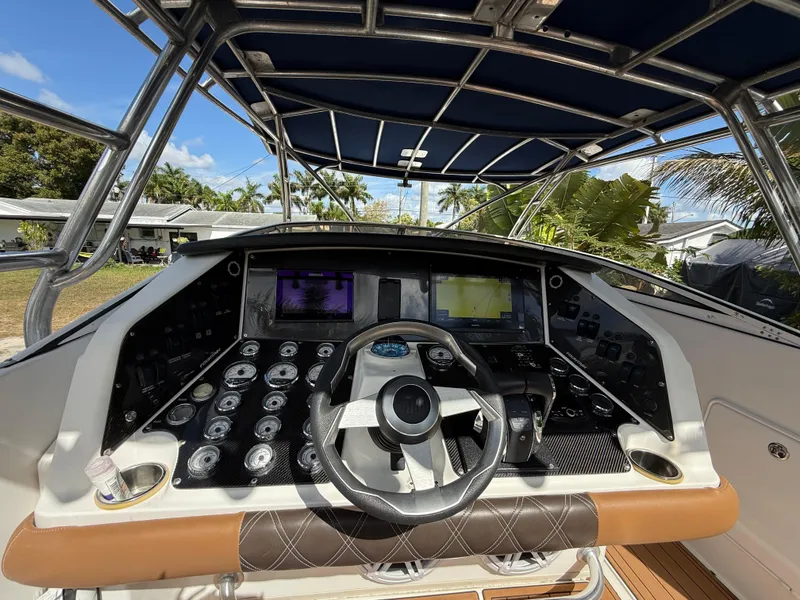 Slide: The Image of Cockpit of 2010 Fountain 38 LX boat with steering wheel and navigation controls. - 18