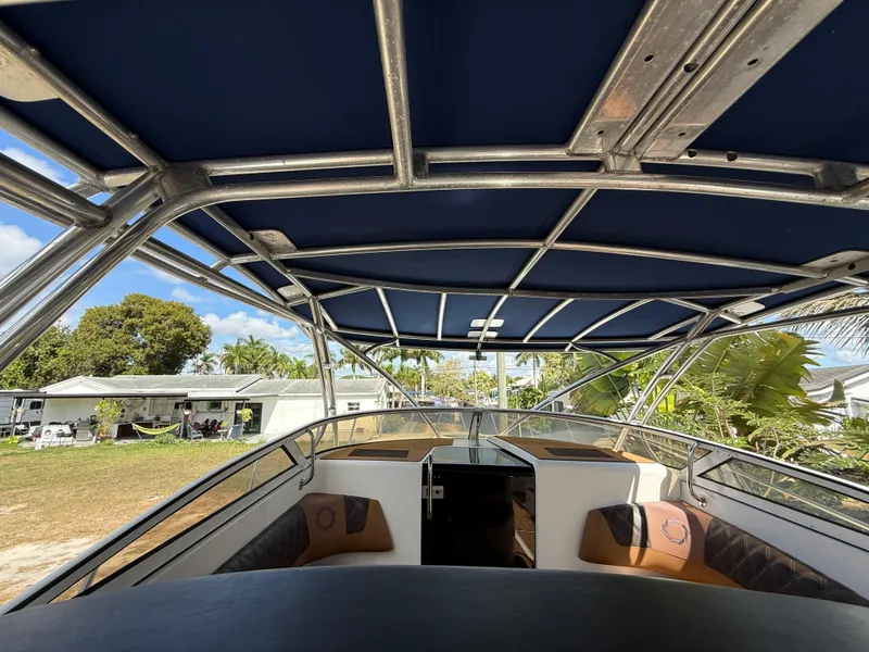 Slide: The Image of 2010 Fountain 38 LX boat interior with canopy, showcasing seating and open cabin. - 23