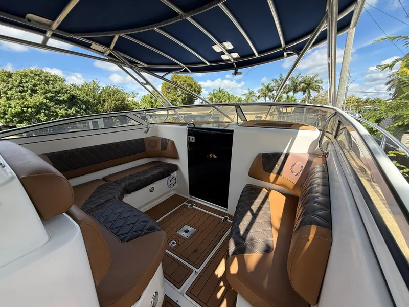 Slide: The Image of 2010 Fountain 38 LX boat interior with brown seating and blue canopy. - 24