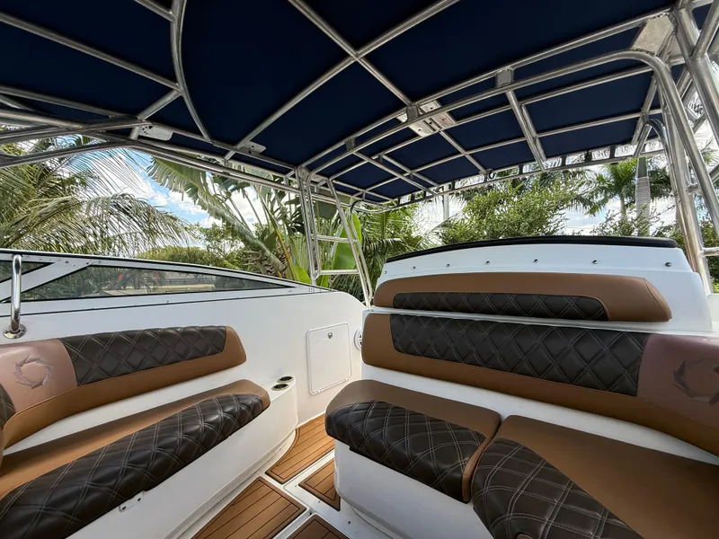 Slide: The Image of Interior view of 2010 Fountain 38 LX boat with cushioned seating and canopy. - 25