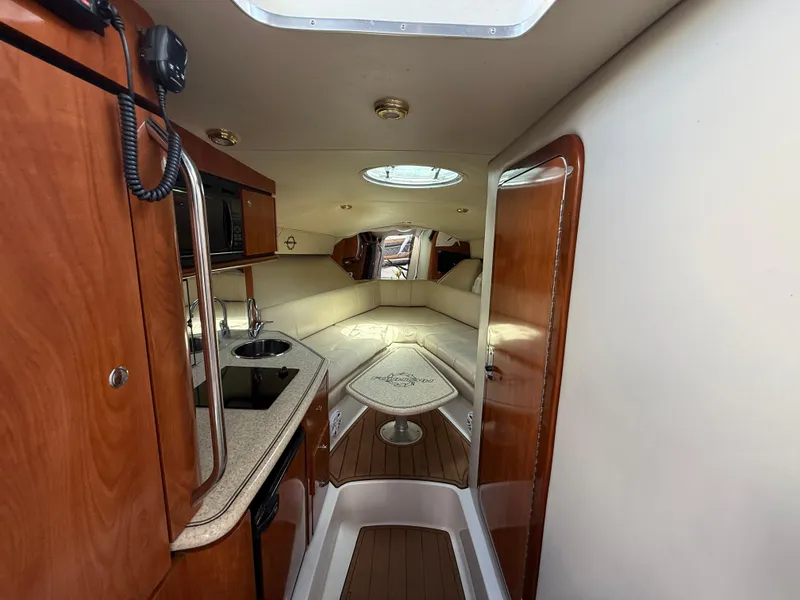 Slide: The Image of 2010 Fountain 38 LX cabin interior with kitchenette, seating, and wood accents. - 27