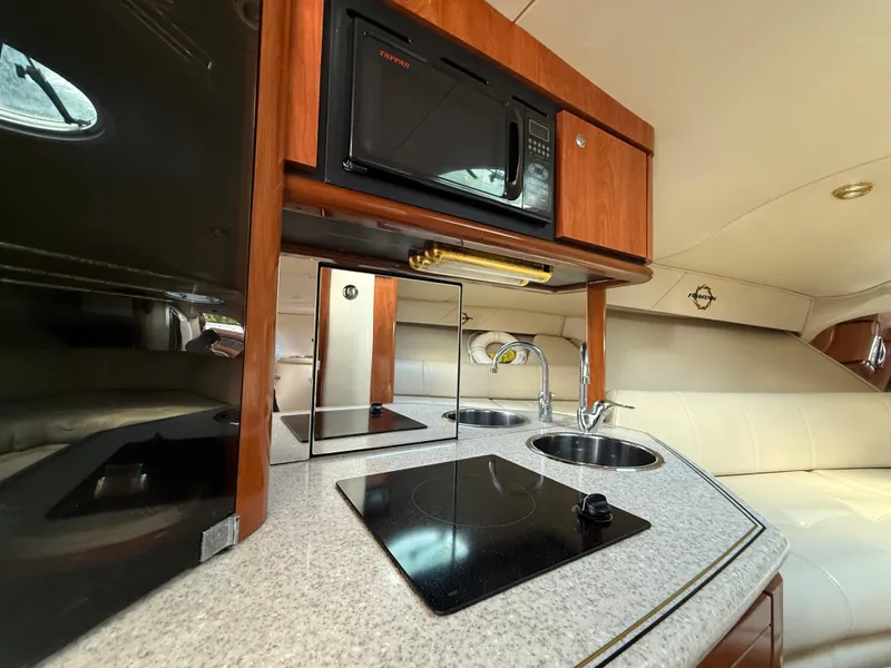 Slide: The Image of Compact kitchen area in a 2010 Fountain 38 LX boat with microwave and stove. - 29