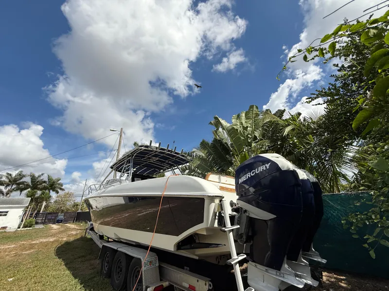 Slide: The Image of 2010 Fountain 38 LX boat on trailer, with Mercury engines, under a partly cloudy sky. - 3