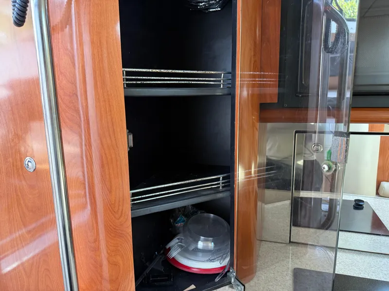 Slide: The Image of Wooden cabinet interior with shelves in a 2010 Fountain 38 LX boat. - 31
