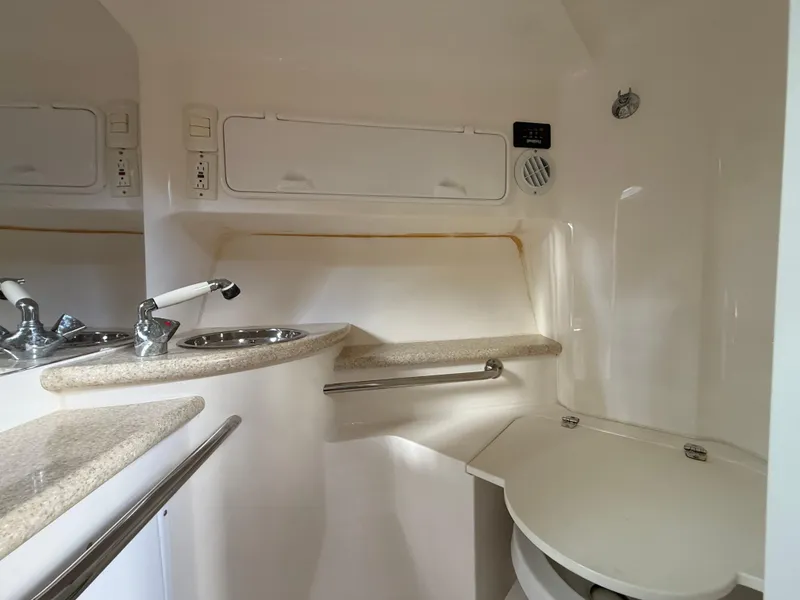 Slide: The Image of Interior of 2010 Fountain 38 LX boat, featuring a compact bathroom with sink and storage. - 35